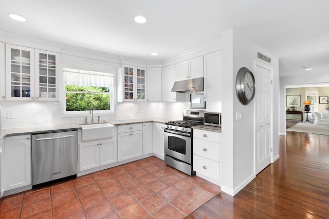 91 Howell St, Southampton, NY 11968 - kitchen with stainless steel appliances, under cabinet range hood, backsplash, glass insert cabinets, and recessed lighting