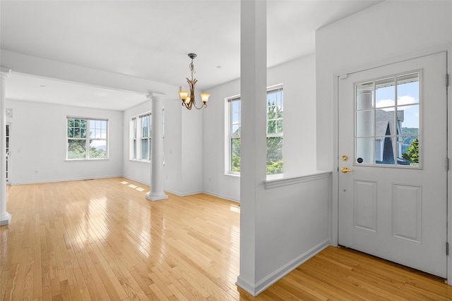 402 Waterview Dr, Poughkeepsie, NY 12601 - entrance foyer with decorative columns, light wood-style flooring, and a chandelier