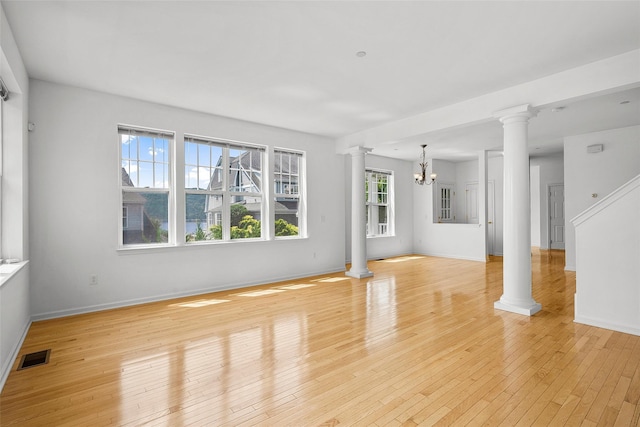 402 Waterview Dr, Poughkeepsie, NY 12601 - unfurnished living room with decorative columns, a chandelier, and light wood-style flooring