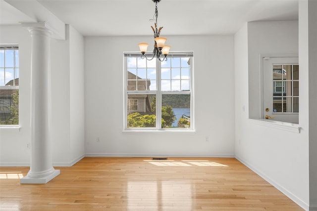 402 Waterview Dr, Poughkeepsie, NY 12601 - unfurnished dining area featuring decorative columns, wood-type flooring, and a chandelier