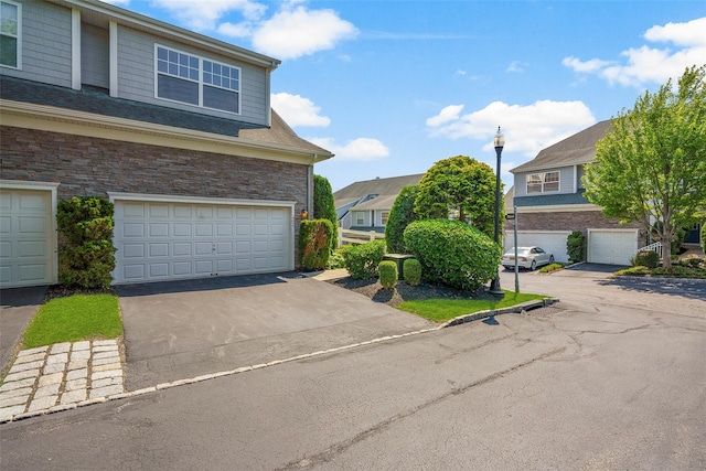 402 Waterview Dr, Poughkeepsie, NY 12601 - view of property exterior with an attached garage, stone siding, driveway, and a residential view