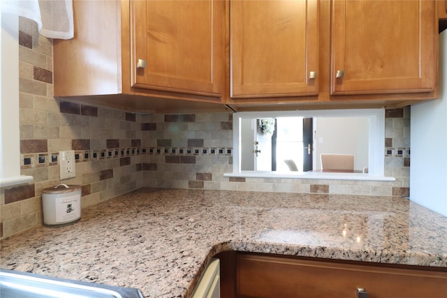 18 Hastings Ct Unit E, Yorktown Heights, NY 10598 - kitchen with backsplash, brown cabinetry, and light stone counters