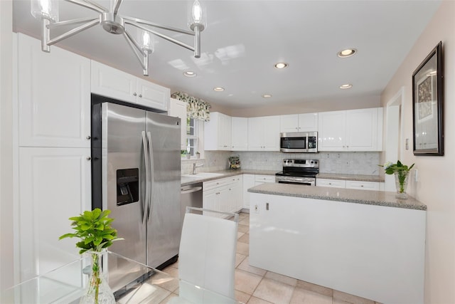15 Deertree Ln, Briarcliff Manor, NY 10510 - kitchen with stainless steel appliances, backsplash, white cabinetry, recessed lighting, and a chandelier
