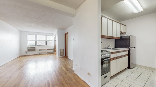 8420 153rd Ave Unit 6H, Howard Beach, NY 11414 - kitchen with appliances with stainless steel finishes, white cabinetry, light wood-type flooring, light countertops, and a textured ceiling