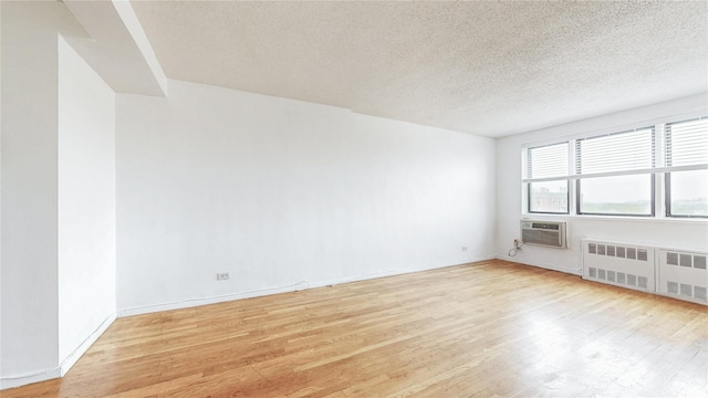 8420 153rd Ave Unit 6H, Howard Beach, NY 11414 - empty room with radiator, light wood-style floors, and a textured ceiling