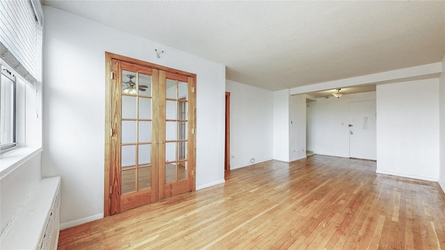 8420 153rd Ave Unit 6H, Howard Beach, NY 11414 - spare room with light wood-type flooring, french doors, ceiling fan, and a textured ceiling