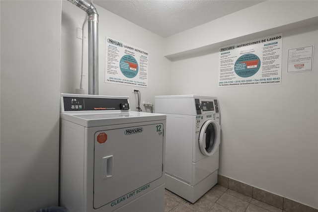 8420 153rd Ave Unit 6H, Howard Beach, NY 11414 - community laundry featuring washing machine and clothes dryer, tile patterned flooring, and a textured ceiling