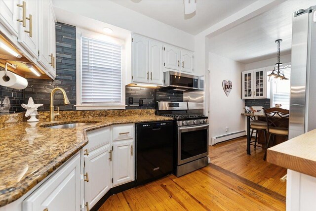 2 Croydon Dr, North Bellmore, NY 11710 - kitchen with stainless steel appliances, a baseboard radiator, white cabinets, backsplash, and light wood finished floors