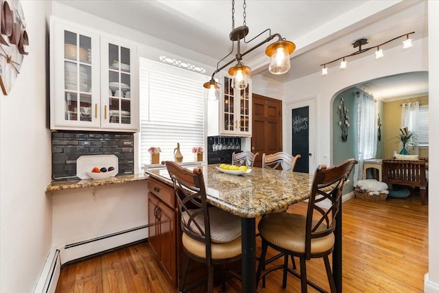 2 Croydon Dr, North Bellmore, NY 11710 - dining area featuring arched walkways, dark wood-type flooring, and a baseboard heating unit