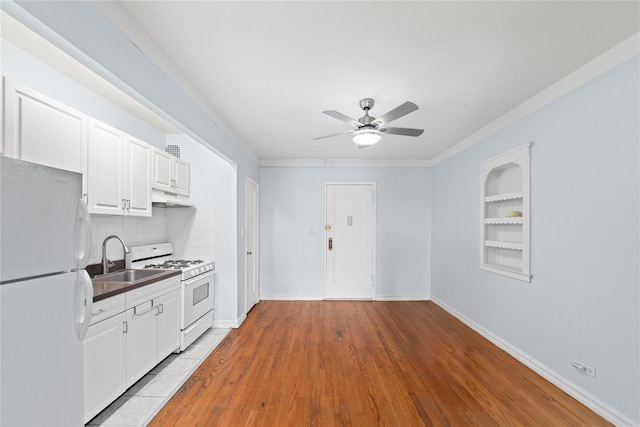 9437 Shore Rd Unit E6, Brooklyn, NY 11209 - kitchen featuring white appliances, under cabinet range hood, a ceiling fan, dark countertops, and decorative backsplash