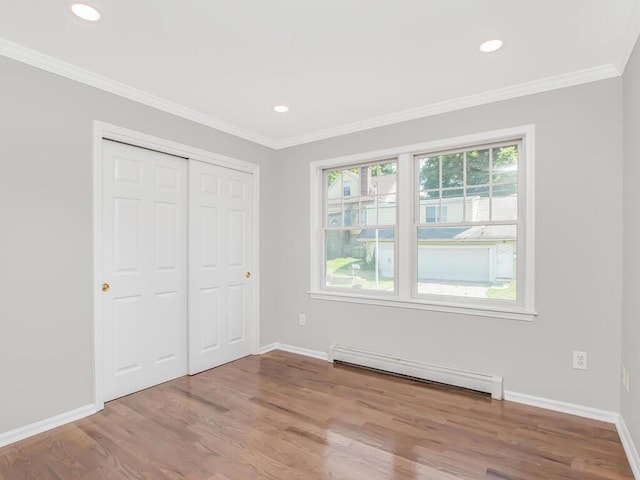 237 Brady Ave, Hawthorne, NY 10532 - unfurnished bedroom featuring baseboard heating, wood finished floors, a closet, recessed lighting, and crown molding