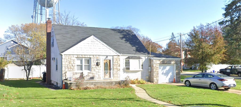 58 Weberfield, Freeport, NY 11520 - view of front of house with a garage, stone siding, a front lawn, a chimney, and driveway