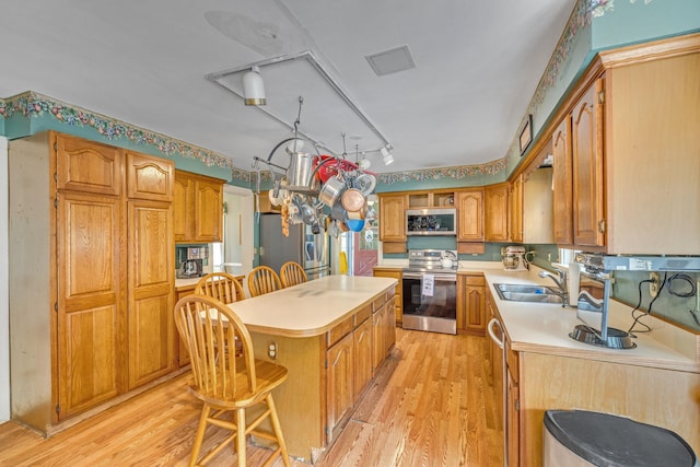 2 Gerri Ct, Wallkill, NY 12589 - kitchen with appliances with stainless steel finishes, a center island, light wood-style floors, and light countertops