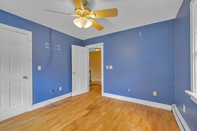 2 Gerri Ct, Wallkill, NY 12589 - unfurnished bedroom featuring a baseboard radiator, wood finished floors, and ceiling fan