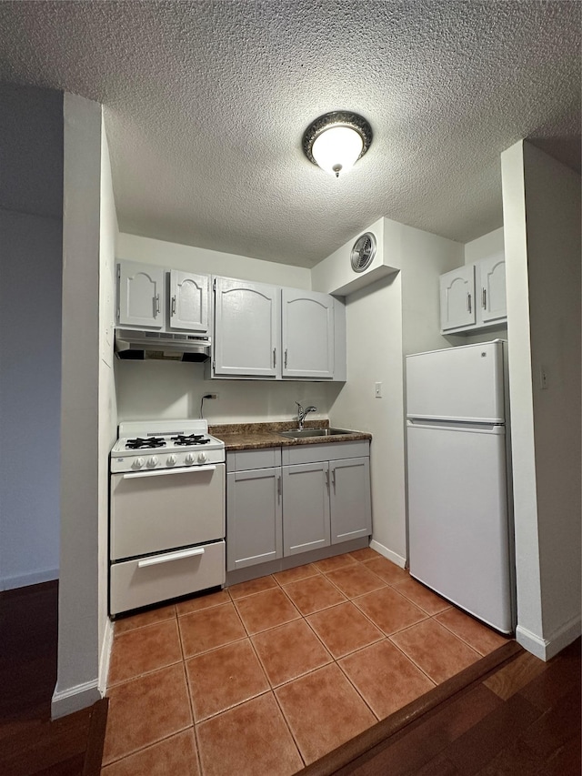 15038 Union Tpke Unit 3D, Kew Garden Hills, NY 11367 - kitchen featuring white appliances, under cabinet range hood, dark countertops, a textured ceiling, and light tile patterned floors
