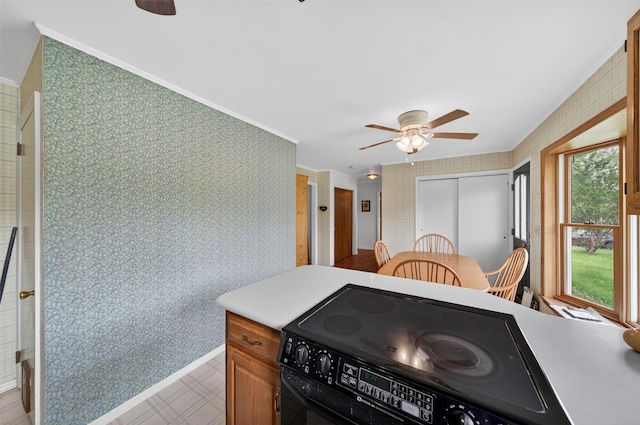 11 Seth Dr, New Hampton, NY 10958 - kitchen featuring black / electric stove, ceiling fan, wallpapered walls, light countertops, and crown molding