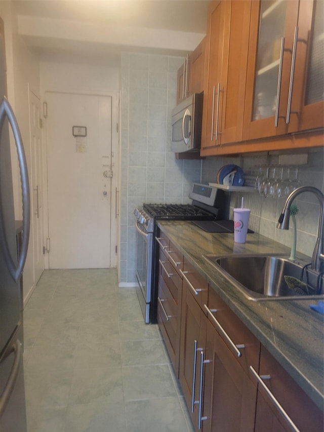 9 Fordham Hill Oval Unit 5C, Bronx, NY 10468 - kitchen with stainless steel range with gas stovetop, fridge, brown cabinetry, glass insert cabinets, and tasteful backsplash