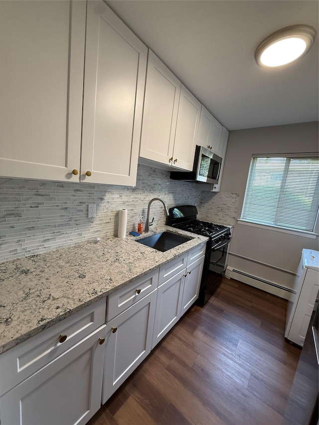 77 Adams Rd Unit 1D, Central Islip, NY 11722 - kitchen with black gas range oven, a baseboard radiator, stainless steel microwave, dark wood-style floors, and white cabinets