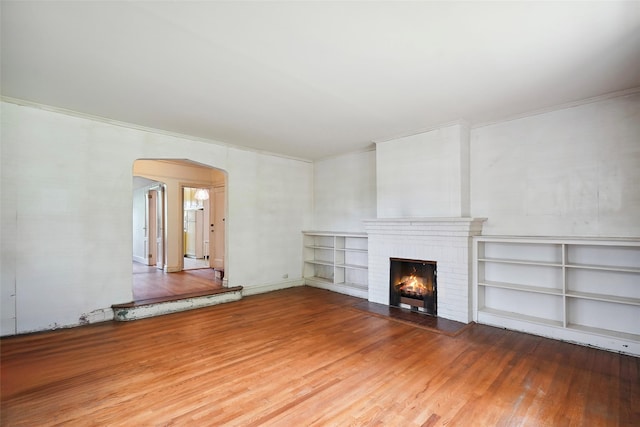 9 Bacon Ct, Bronxville, NY 10708 - unfurnished living room with arched walkways, wood finished floors, ornamental molding, and a brick fireplace