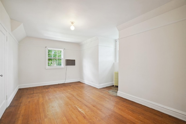 9 Bacon Ct, Bronxville, NY 10708 - unfurnished room with wood finished floors, a wall unit AC, vaulted ceiling, and radiator