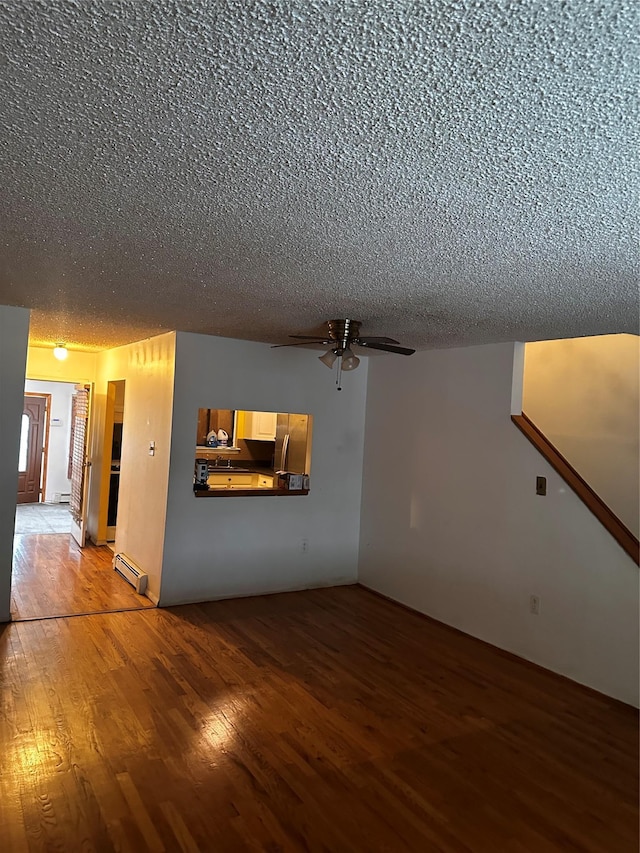 569 Warwick St, Brooklyn, NY 11207 - unfurnished living room with a textured ceiling, light wood-style floors, ceiling fan, and a baseboard heating unit