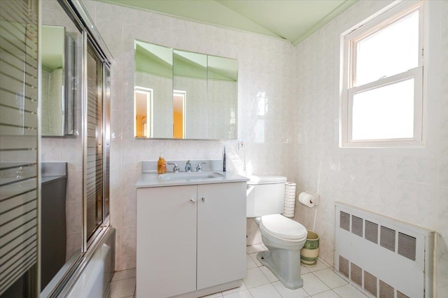 3478 Woodward St, Oceanside, NY 11572 - full bath featuring radiator heating unit, tile walls, vanity, shower / bath combination with glass door, and tile patterned floors