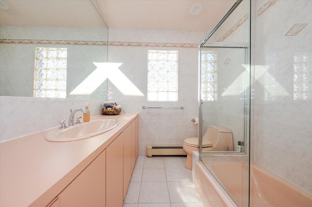 3478 Woodward St, Oceanside, NY 11572 - full bath featuring a baseboard heating unit, tile patterned floors, vanity, tile walls, and enclosed tub / shower combo