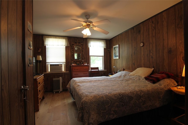 3155 Lexington Ave Unit 18Ab, Mohegan Lake, NY 10567 - bedroom with radiator heating unit, light wood-type flooring, wooden walls, cooling unit, and ceiling fan