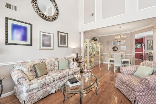 17 Meadow Pond Cir, Miller Place, NY 11764 - living room featuring ornate columns, crown molding, wood finished floors, and a chandelier