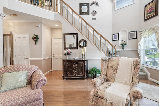 17 Meadow Pond Cir, Miller Place, NY 11764 - living room featuring wood finished floors, a high ceiling, stairs, and ornamental molding
