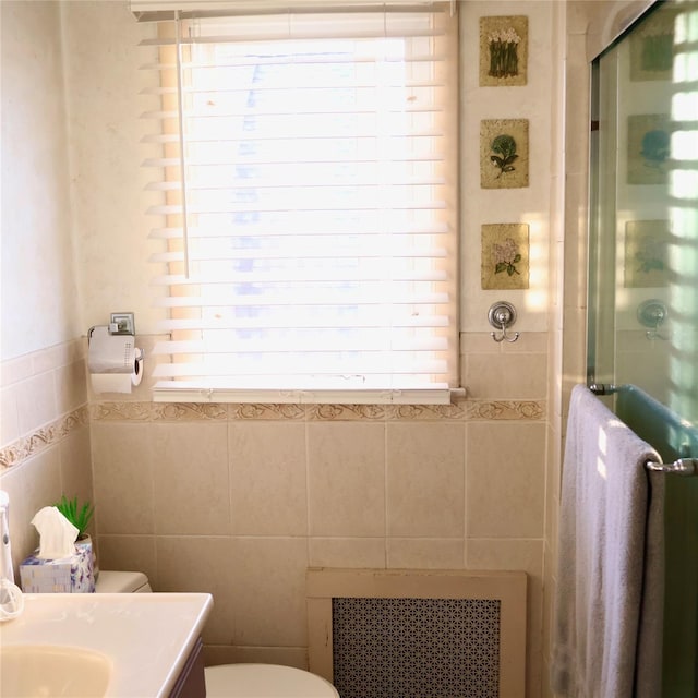 24 Pine St, Oceanside, NY 11572 - bathroom with a stall shower, tile walls, vanity, and radiator heating unit