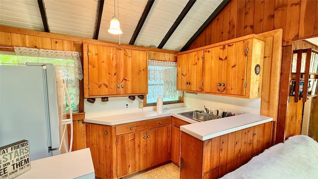 3300 Baker St Unit 16, Mohegan Lake, NY 10547 - kitchen with freestanding refrigerator, wooden walls, healthy amount of natural light, light countertops, and brown cabinetry
