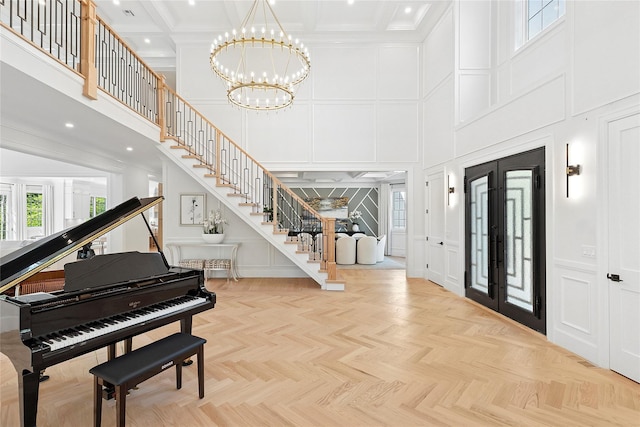 17 Chelsea Pl, Dix Hills, NY 11746 - entryway featuring a decorative wall, a high ceiling, stairs, a chandelier, and french doors