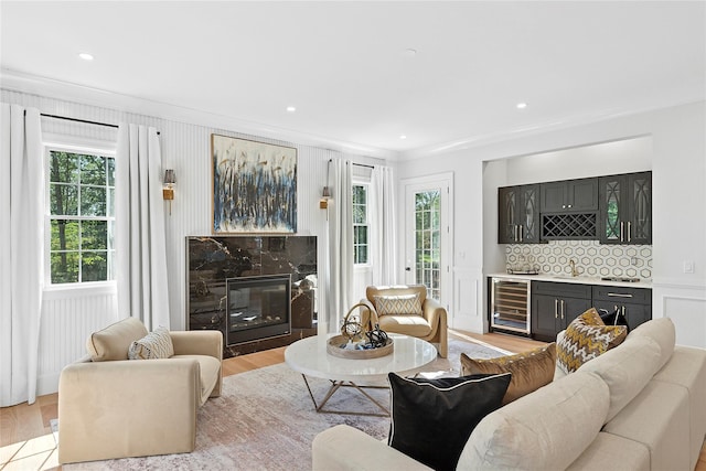 17 Chelsea Pl, Dix Hills, NY 11746 - living room with beverage cooler, bar with sink, light wood finished floors, crown molding, and a premium fireplace