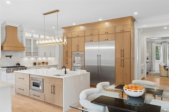 17 Chelsea Pl, Dix Hills, NY 11746 - kitchen with stainless steel appliances, premium range hood, light brown cabinets, light wood finished floors, and decorative backsplash