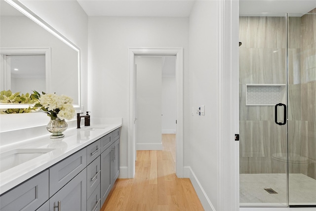 17 Chelsea Pl, Dix Hills, NY 11746 - bathroom featuring double vanity, a stall shower, and wood finished floors