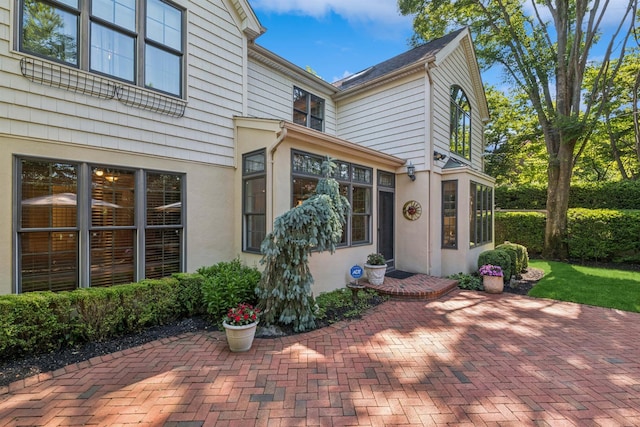 42 Roxen Rd, Rockville Centre, NY 11570 - doorway to property with a patio area and stucco siding