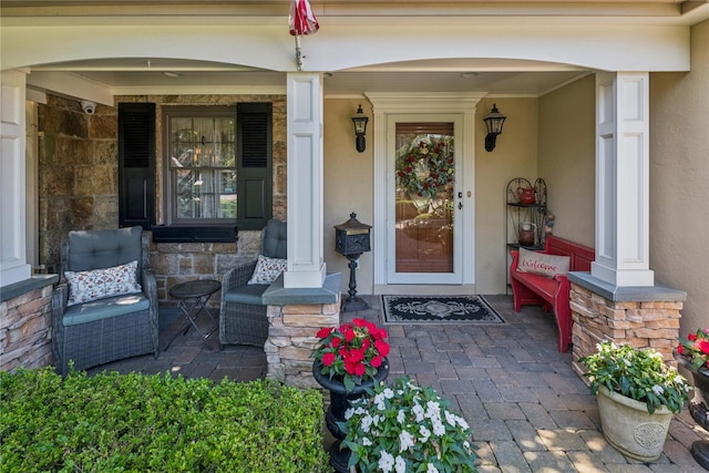42 Roxen Rd, Rockville Centre, NY 11570 - doorway to property with stone siding, covered porch, and stucco siding
