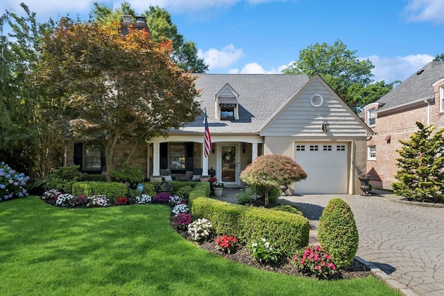 42 Roxen Rd, Rockville Centre, NY 11570 - cape cod-style house featuring an attached garage, a front yard, decorative driveway, and a porch