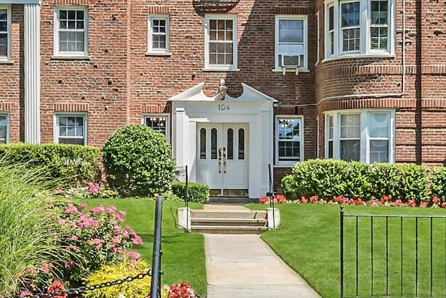 104 S Village Ave S Unit 1F, Rockville Centre, NY 11570 - doorway to property with brick siding, a yard, and cooling unit