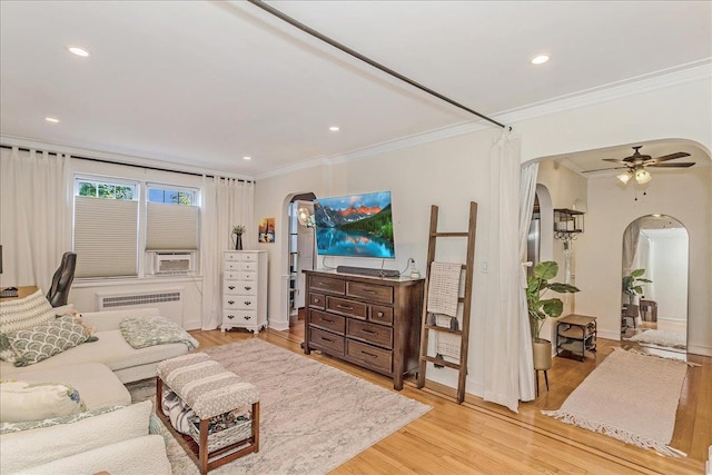 104 S Village Ave S Unit 1F, Rockville Centre, NY 11570 - living room with arched walkways, radiator, ornamental molding, light wood-type flooring, and ceiling fan