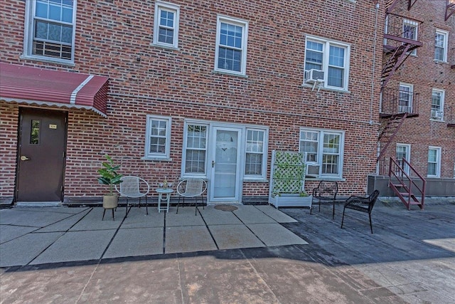 104 S Village Ave S Unit 1F, Rockville Centre, NY 11570 - back of property featuring brick siding, a patio area, and cooling unit