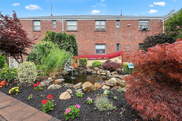 160-54 Willets Point Blvd Unit 4-206, Whitestone, NY 11357 - view of building exterior with cooling unit and a garden pond