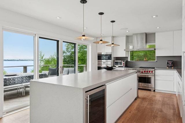 55C Shore Rd, Shelter Island, NY 11964 - kitchen with appliances with stainless steel finishes, beverage cooler, wall chimney range hood, modern cabinets, and white cabinetry