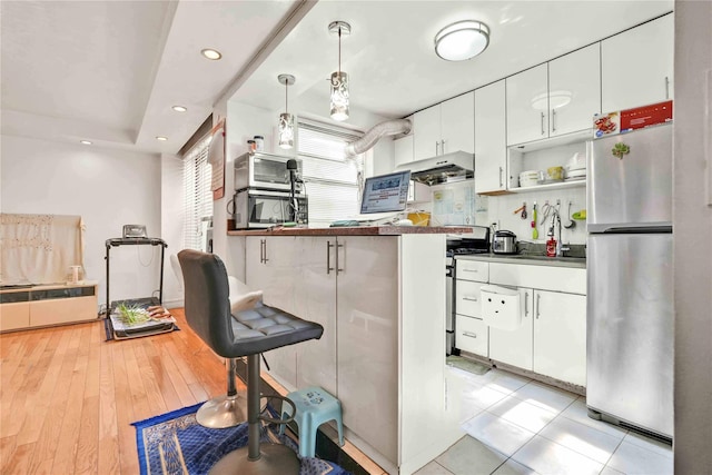 141-15 28th Ave Unit 1G, Flushing, NY 11354 - kitchen featuring stainless steel appliances, under cabinet range hood, white cabinetry, a breakfast bar area, and recessed lighting