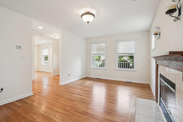 37 Baxter Rd, Pawling, NY 12564 - unfurnished living room with plenty of natural light, a tiled fireplace, and light wood finished floors