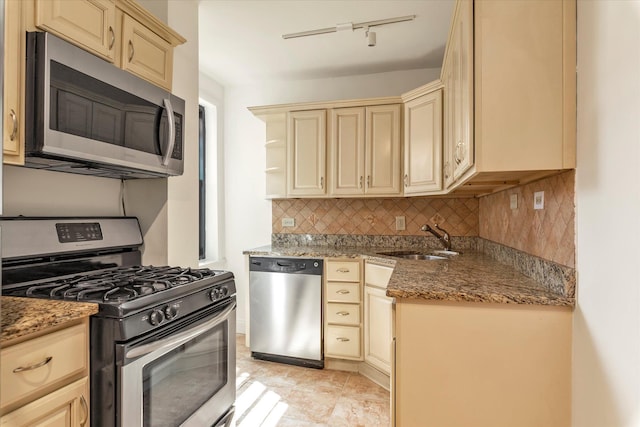 212-04 75th Ave Unit 4J, Bayside, NY 11364 - kitchen featuring stainless steel appliances, cream cabinetry, backsplash, stone countertops, and track lighting