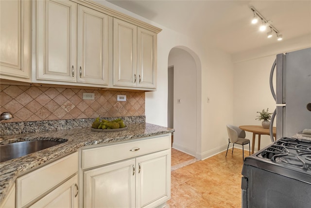 212-04 75th Ave Unit 4J, Bayside, NY 11364 - kitchen featuring cream cabinets, freestanding refrigerator, gas range oven, and arched walkways