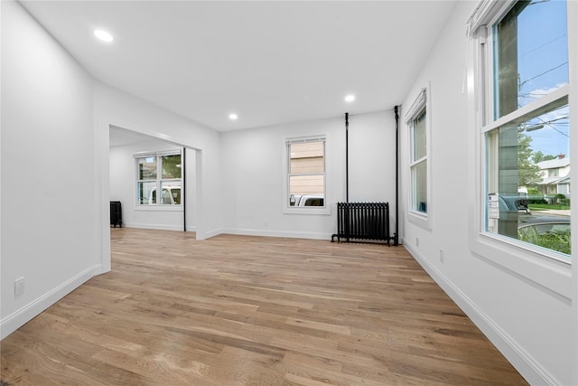 163 Grant Ave, Mineola, NY 11501 - unfurnished living room featuring radiator heating unit, light wood-type flooring, and recessed lighting