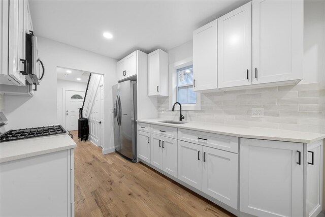 163 Grant Ave, Mineola, NY 11501 - kitchen with stainless steel appliances, tasteful backsplash, white cabinets, light wood finished floors, and recessed lighting